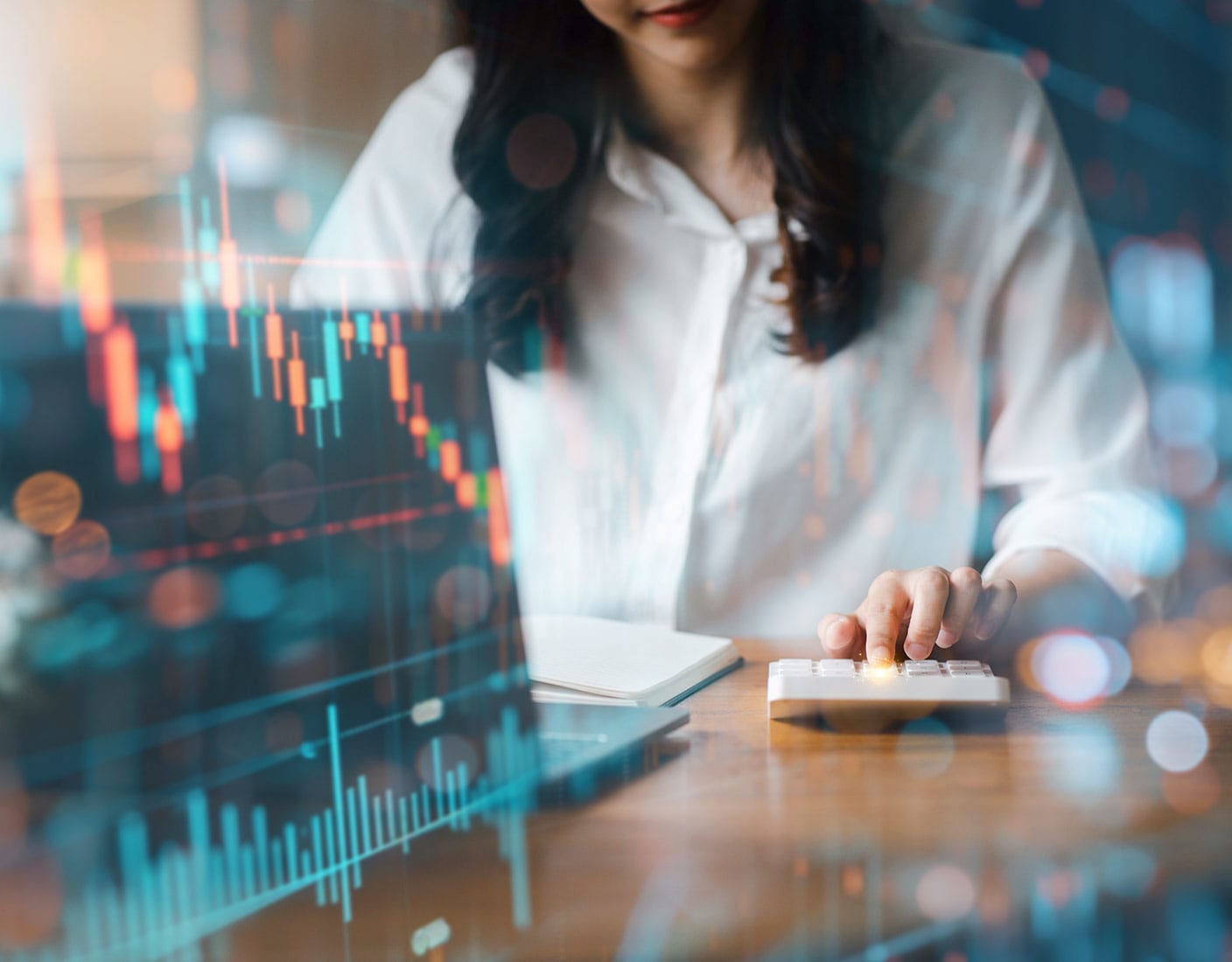 A woman studies a stock chart displayed on her laptop, engaged in financial analysis.