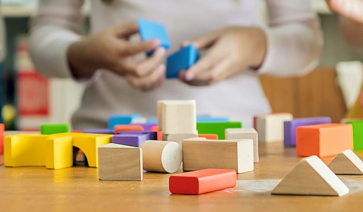 Children joyfully building structures with colorful blocks, fostering creativity and teamwork in early childhood development.