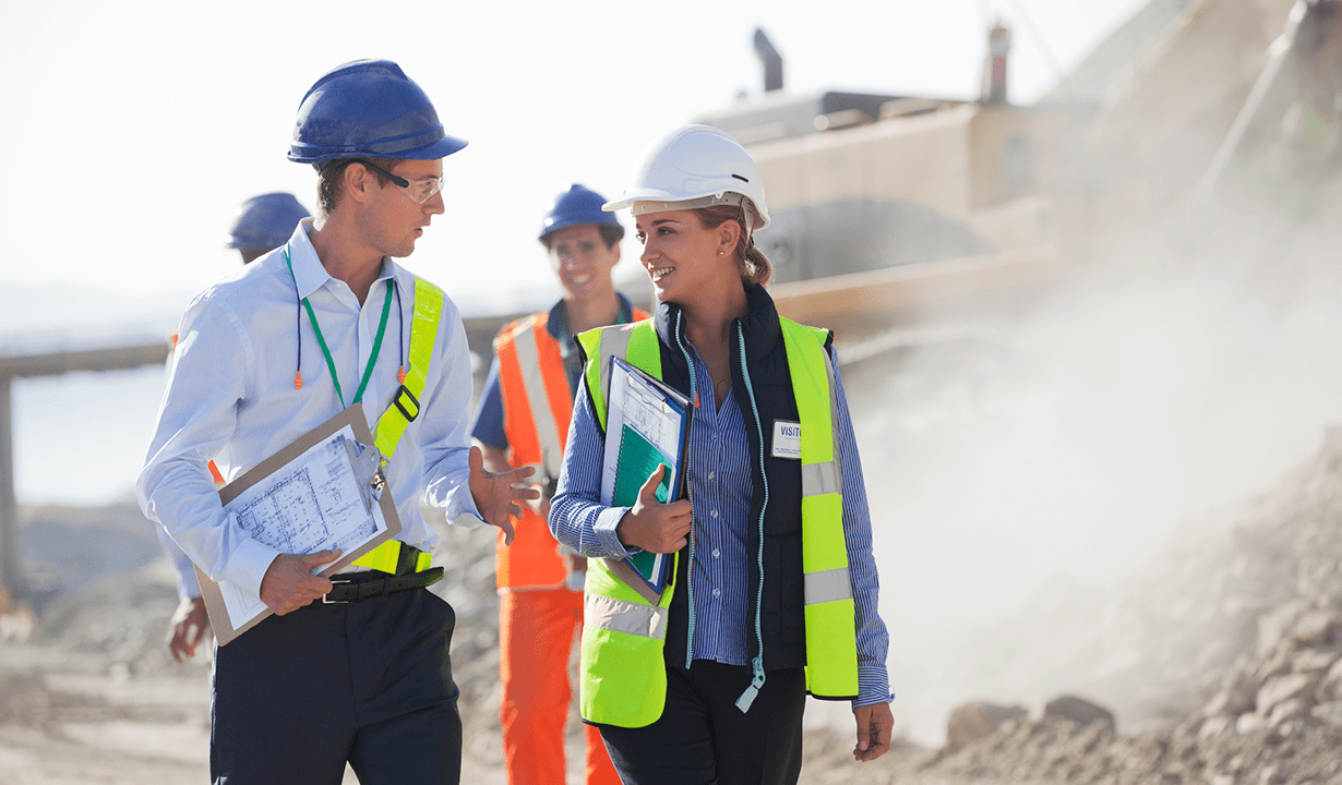 Two construction workers engaged in conversation while on the job site.