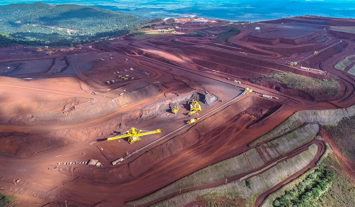 Aerial perspective of an open pit mine, highlighting the vast excavation site and the intricate patterns of the terrain.